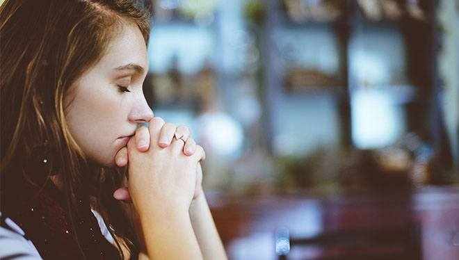 девушка молится с закрытыми глазами